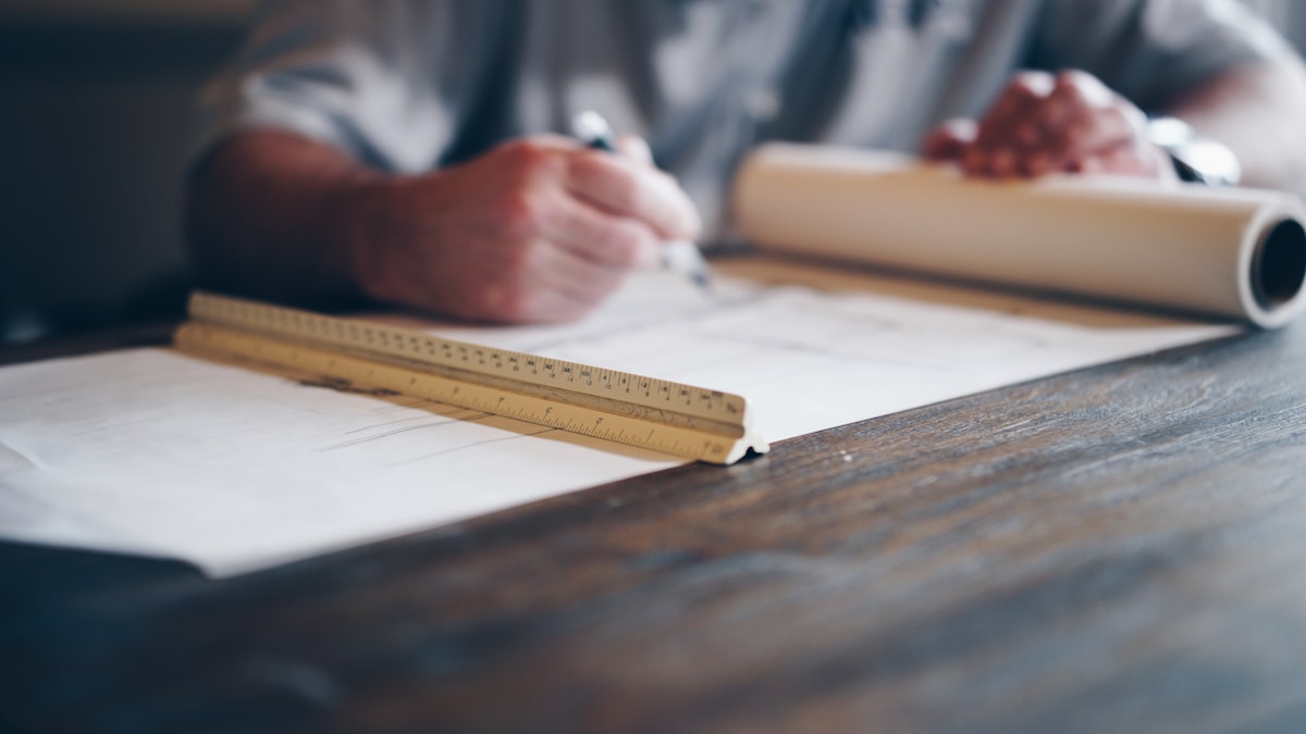 Proceso de dibujo técnico con escuadra y plano